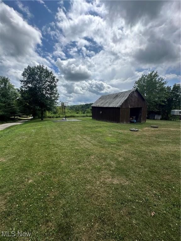 view of yard with an outbuilding, a pole building, and a detached garage