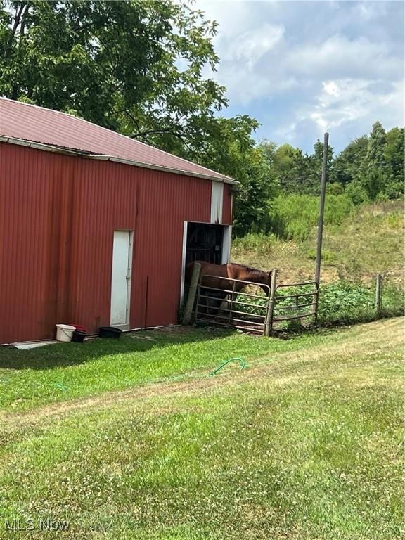 view of pole building with fence and a lawn