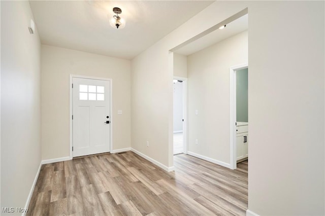 entrance foyer with baseboards and light wood-style floors