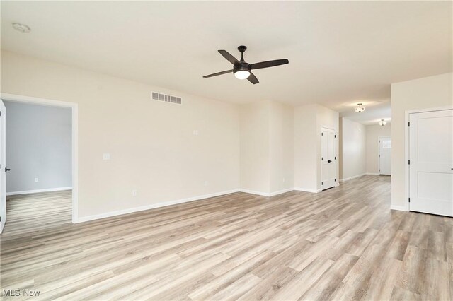 spare room featuring light wood-type flooring, baseboards, visible vents, and a ceiling fan