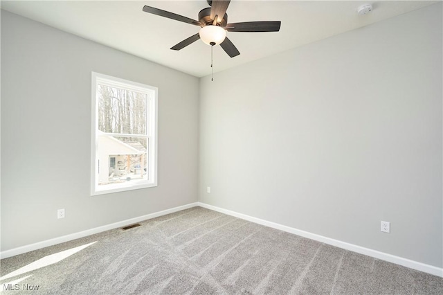 empty room featuring a ceiling fan, carpet flooring, visible vents, and baseboards