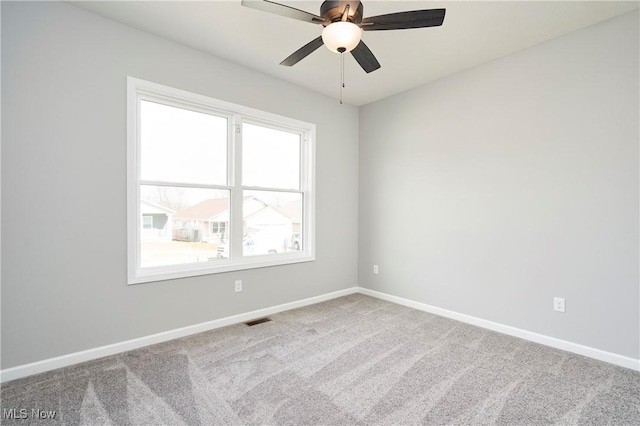 spare room with baseboards, visible vents, ceiling fan, and carpet flooring