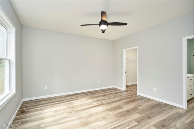 spare room featuring a ceiling fan, baseboards, visible vents, and light wood finished floors