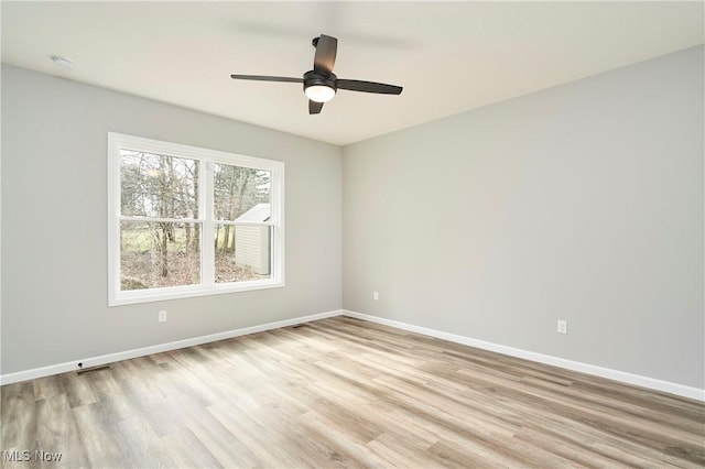 unfurnished room featuring a ceiling fan, baseboards, and wood finished floors