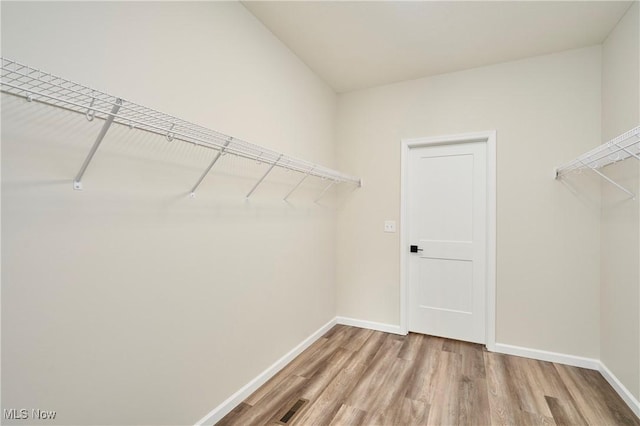 walk in closet featuring visible vents and wood finished floors