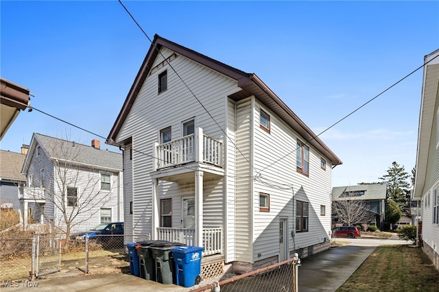 view of side of home featuring fence and a balcony