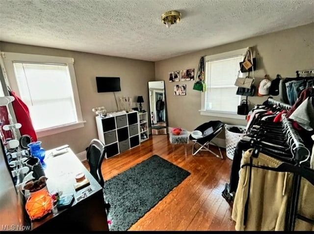 office area with a textured ceiling, hardwood / wood-style floors, and a wealth of natural light