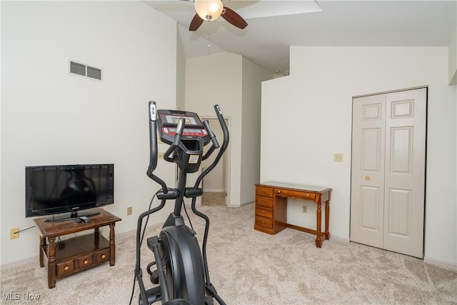 exercise area featuring vaulted ceiling, carpet flooring, visible vents, and a ceiling fan