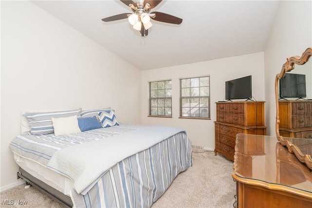 bedroom featuring lofted ceiling, baseboards, a ceiling fan, and light colored carpet