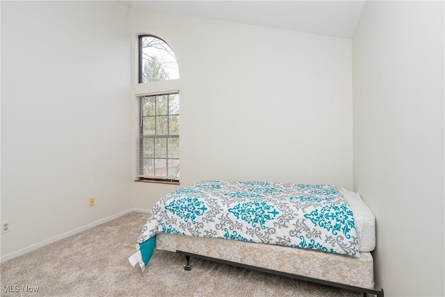 bedroom featuring lofted ceiling, carpet, and baseboards