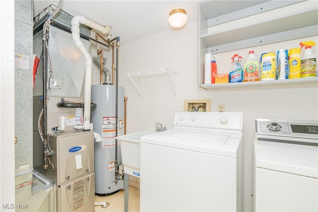 laundry room with laundry area, water heater, separate washer and dryer, and a sink