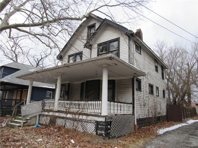 view of front of property featuring covered porch and a chimney