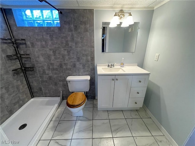 bathroom featuring toilet, vanity, baseboards, marble finish floor, and a shower stall