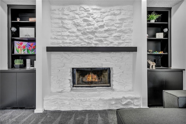 interior details featuring a stone fireplace, built in shelves, and carpet