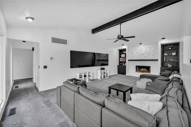 carpeted living room featuring lofted ceiling with beams, a fireplace, visible vents, and a textured ceiling