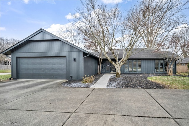 view of front of home featuring a garage, driveway, and fence