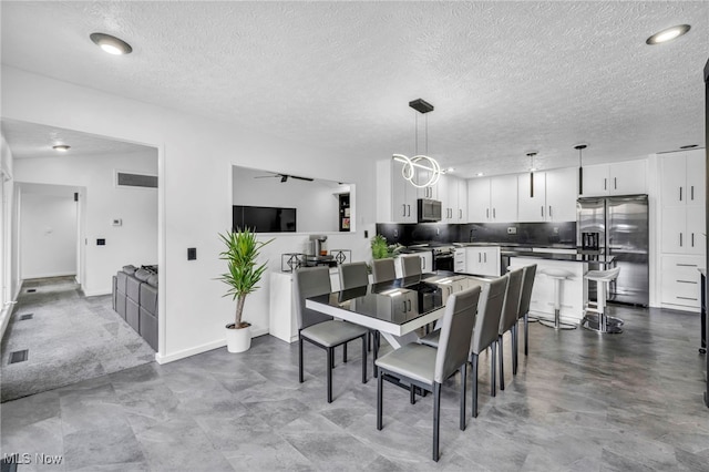 dining space with visible vents and a textured ceiling