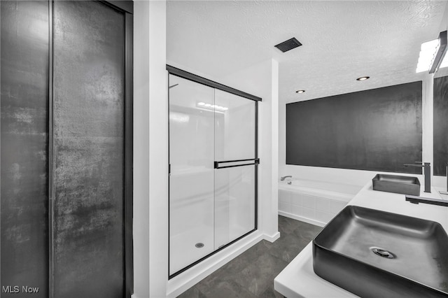 full bathroom with a sink, a textured ceiling, a shower stall, and a bath