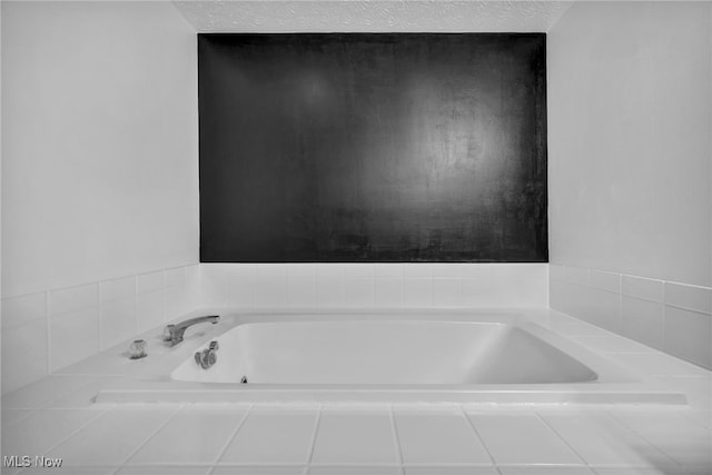 bathroom featuring a textured ceiling and a bath