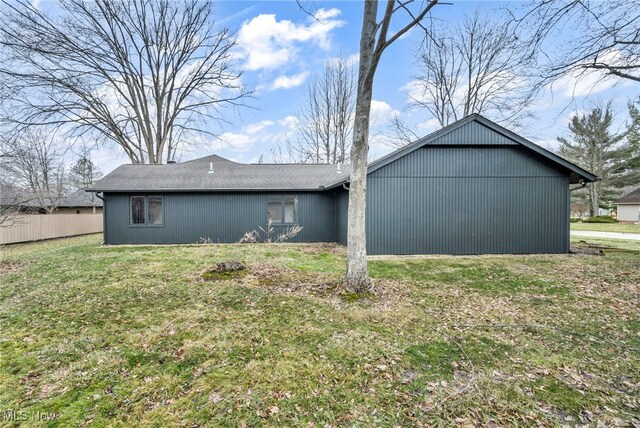 view of side of home featuring a yard and fence