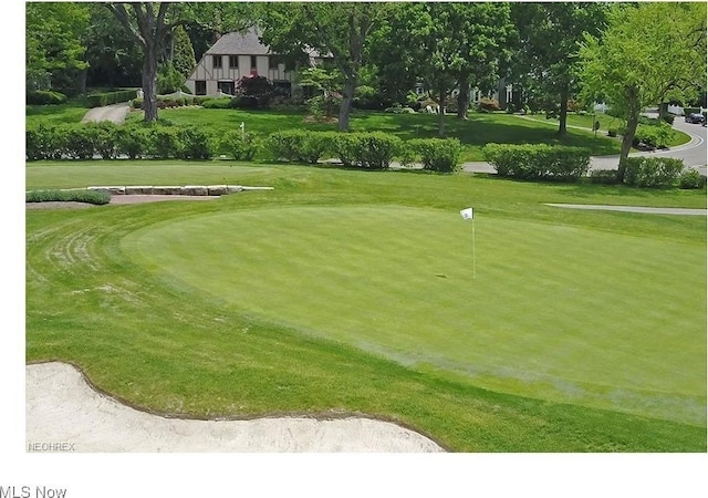 view of home's community featuring a lawn and golf course view