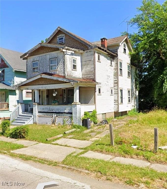 view of front of property featuring covered porch and a chimney