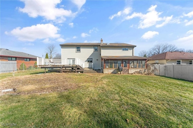 rear view of property featuring a sunroom, a fenced backyard, a lawn, and a wooden deck