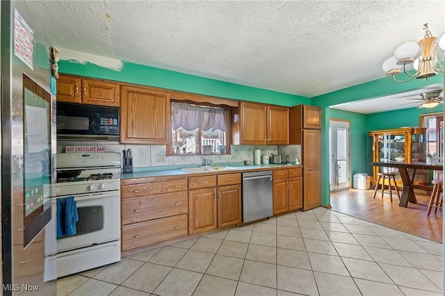 kitchen featuring light tile patterned floors, stainless steel appliances, plenty of natural light, and a sink