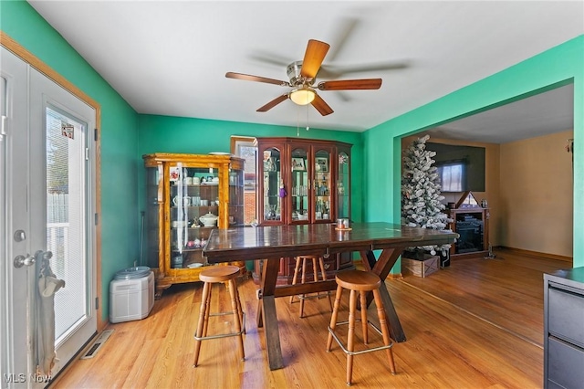 dining space featuring light wood-style floors, visible vents, and plenty of natural light