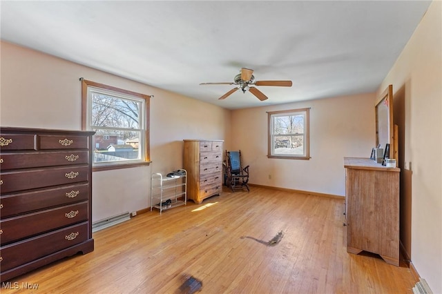 misc room with ceiling fan, light wood-style flooring, baseboards, and baseboard heating