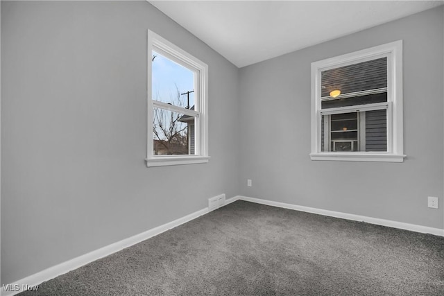 unfurnished room featuring carpet, visible vents, and baseboards