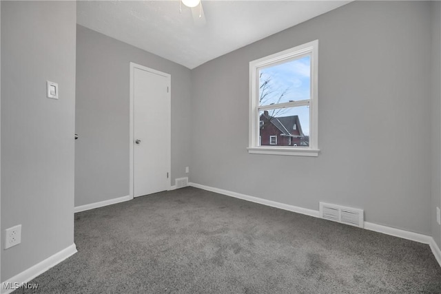 empty room featuring ceiling fan, carpet floors, visible vents, and baseboards