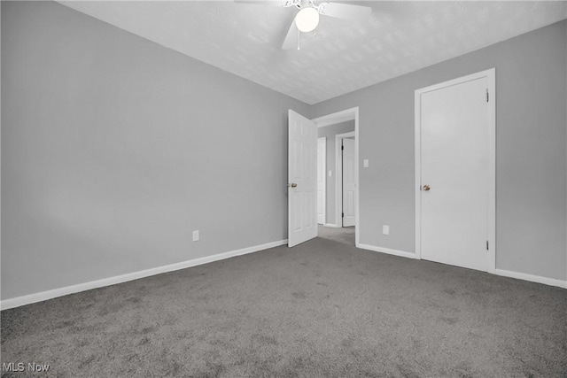 carpeted spare room with ceiling fan and baseboards