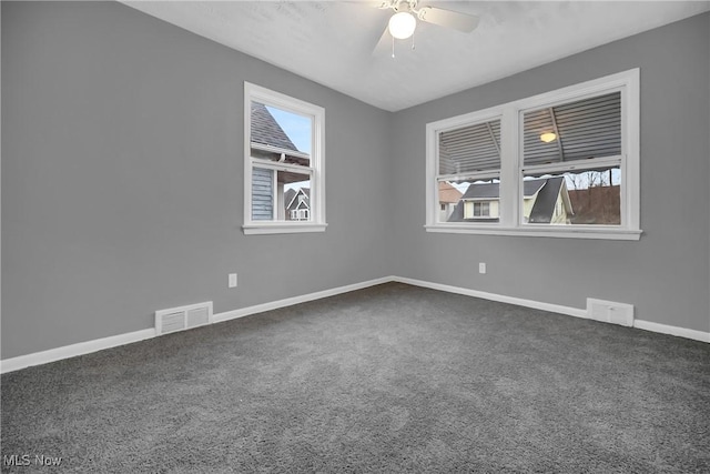 carpeted spare room featuring ceiling fan, visible vents, and baseboards