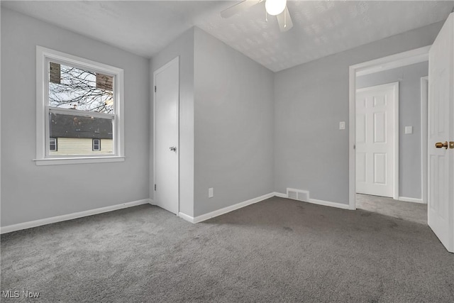 interior space featuring a ceiling fan, visible vents, and baseboards