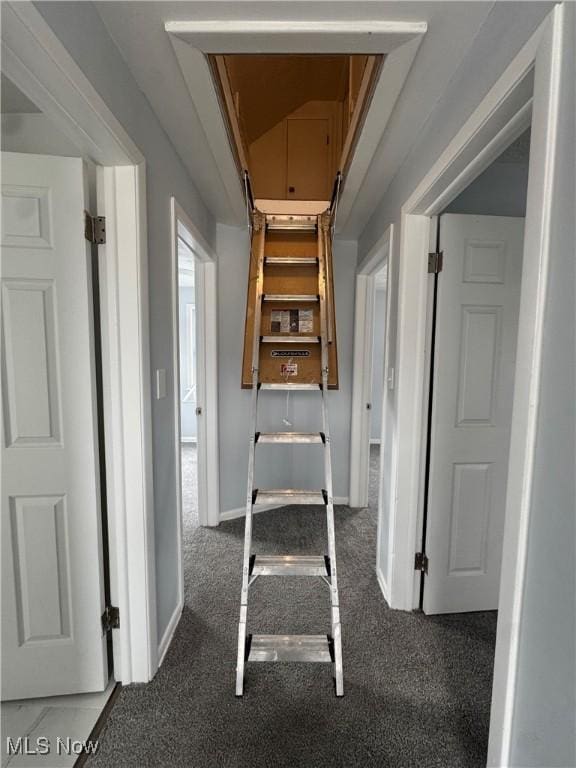 hallway with carpet floors and baseboards