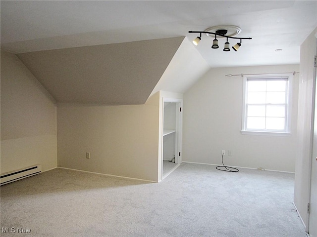 additional living space with a baseboard heating unit, lofted ceiling, carpet floors, and baseboards