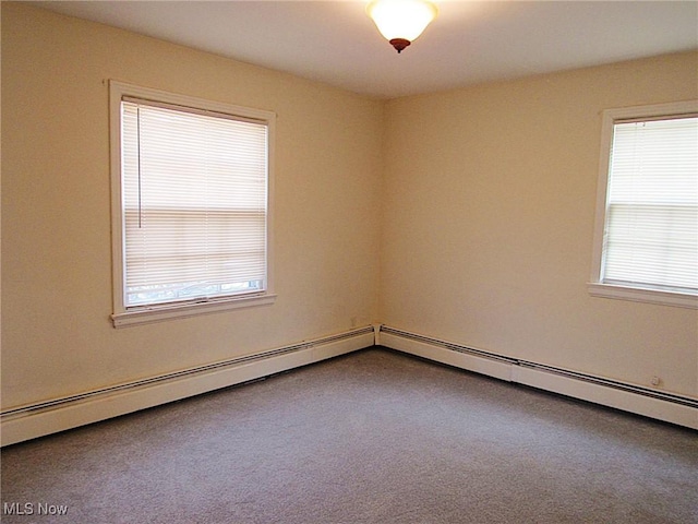 carpeted empty room with a baseboard heating unit