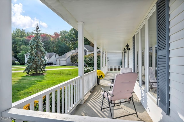 wooden deck featuring a porch and a lawn