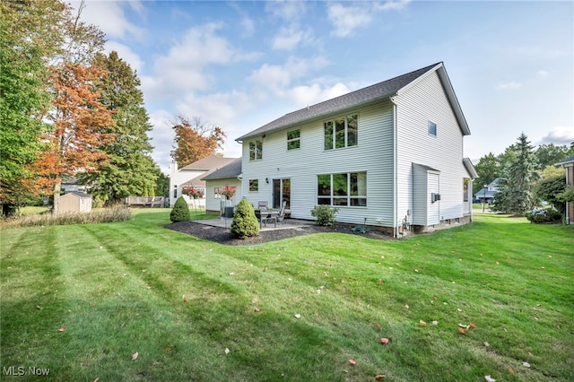 rear view of property featuring an outbuilding, a patio area, a yard, and a shed