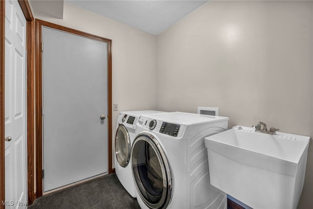 laundry room with dark carpet, laundry area, a sink, and separate washer and dryer