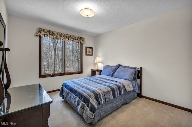 carpeted bedroom featuring baseboards and a textured ceiling