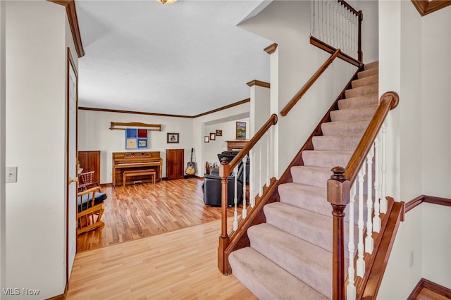 foyer entrance featuring ornamental molding, stairs, baseboards, and wood finished floors