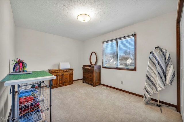 office area with visible vents, light colored carpet, a textured ceiling, and baseboards