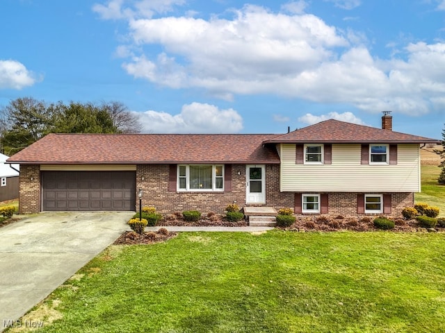 split level home featuring a front lawn, a chimney, an attached garage, and brick siding