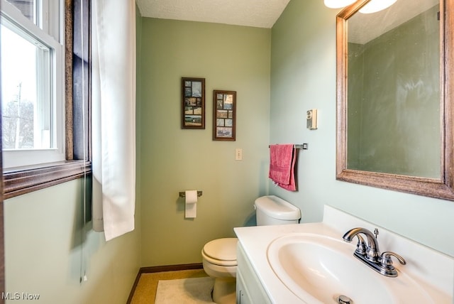 bathroom featuring baseboards, vanity, and toilet