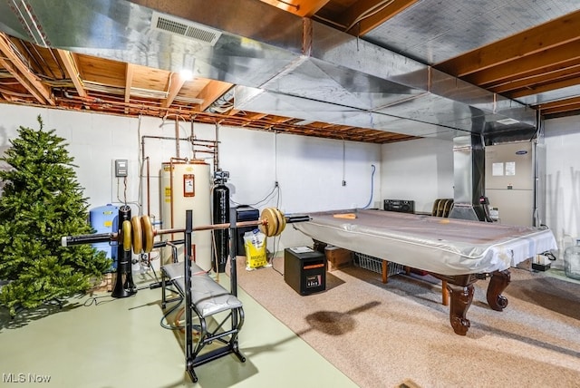 recreation room featuring visible vents, finished concrete flooring, and water heater