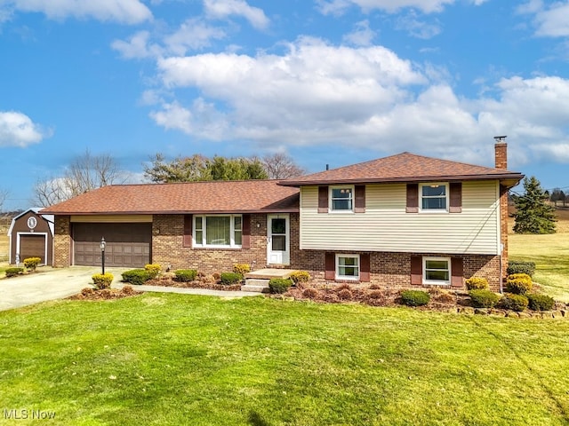 tri-level home featuring brick siding, a chimney, a garage, driveway, and a front lawn