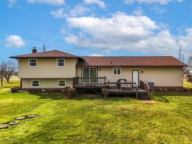 back of property with a lawn, a chimney, and a wooden deck