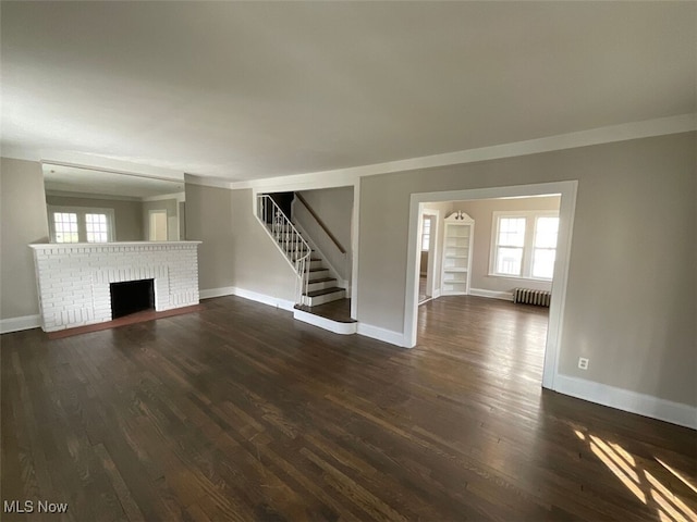 3096 Meadowbrook Blvd, Cleveland Heights, OH 44118 - unfurnished living room with wood finished floors, a brick fireplace, plenty of natural light, and stairs